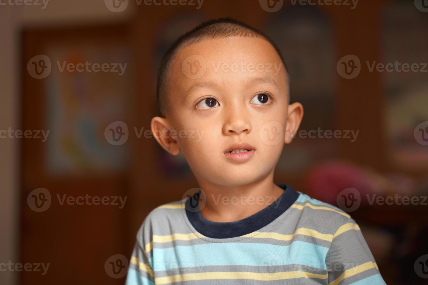 Asian boy looking up at the room photo