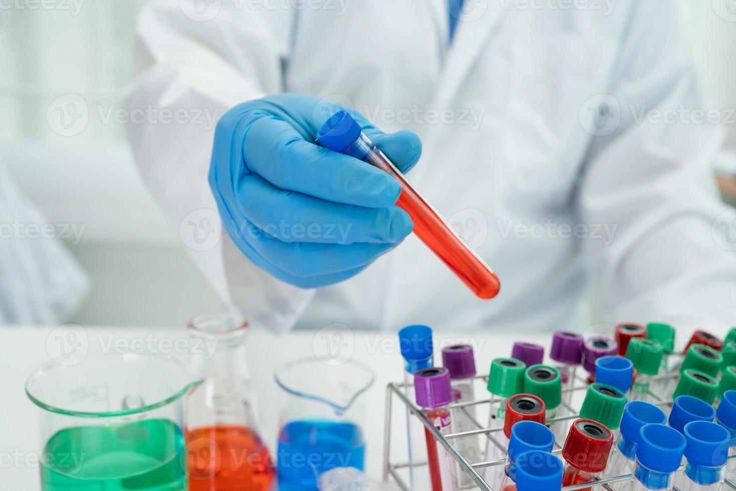 Scientist holding erlenmeyer flask, conical flask glassware with red color liquid solution in science chemistry laboratory. photo