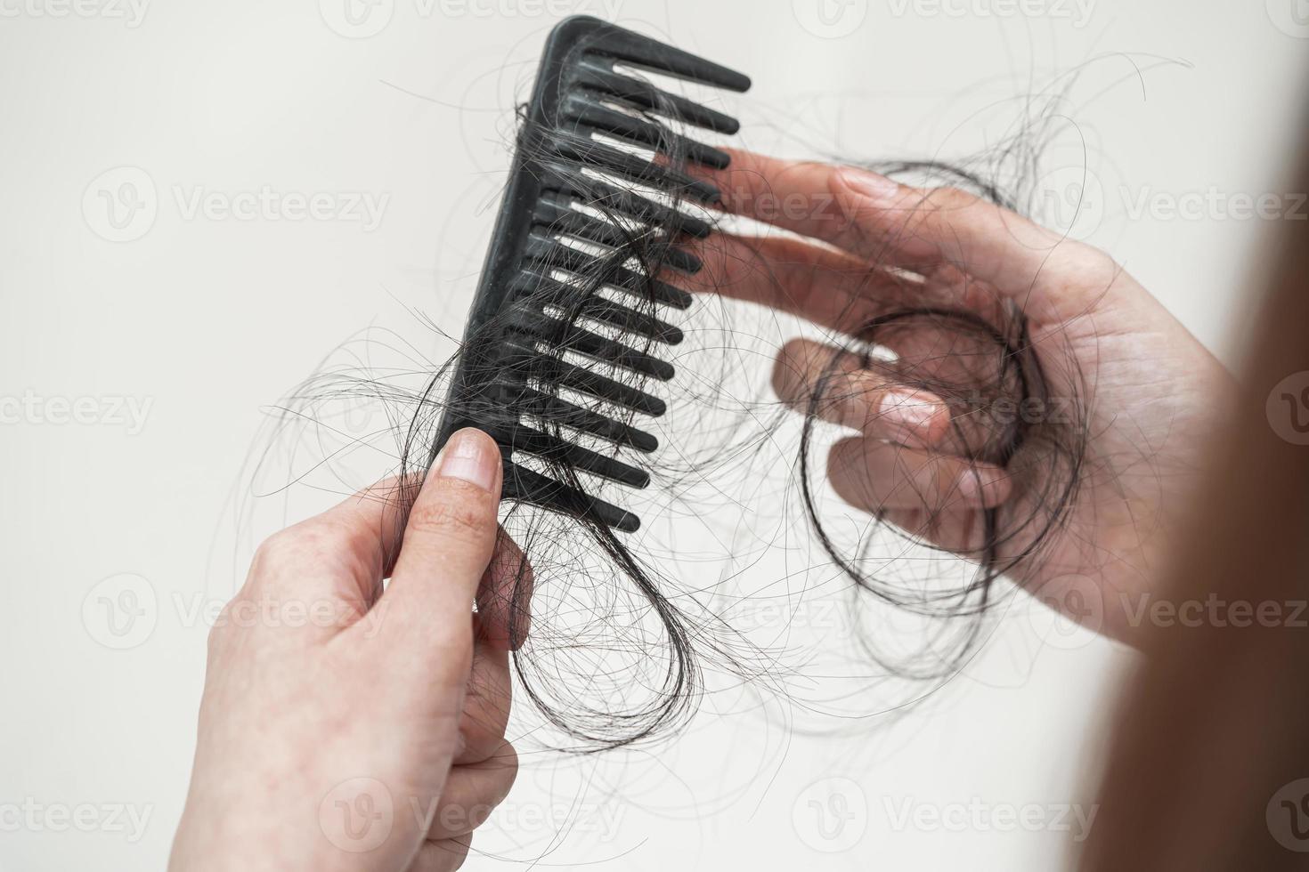 Asian woman have problem with long hair loss attach to comb brush. photo