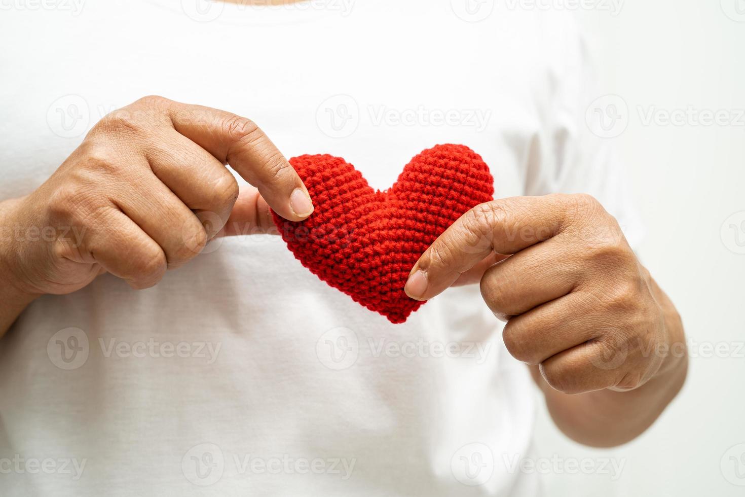 asiático mujer voluntario participación un rojo corazón, donación, caridad, confianza, seguro concepto. foto
