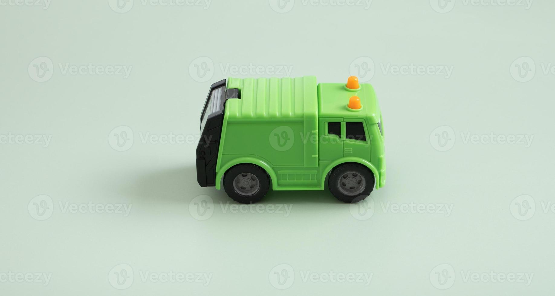 Toy garbage truck and recycle text on a green background photo