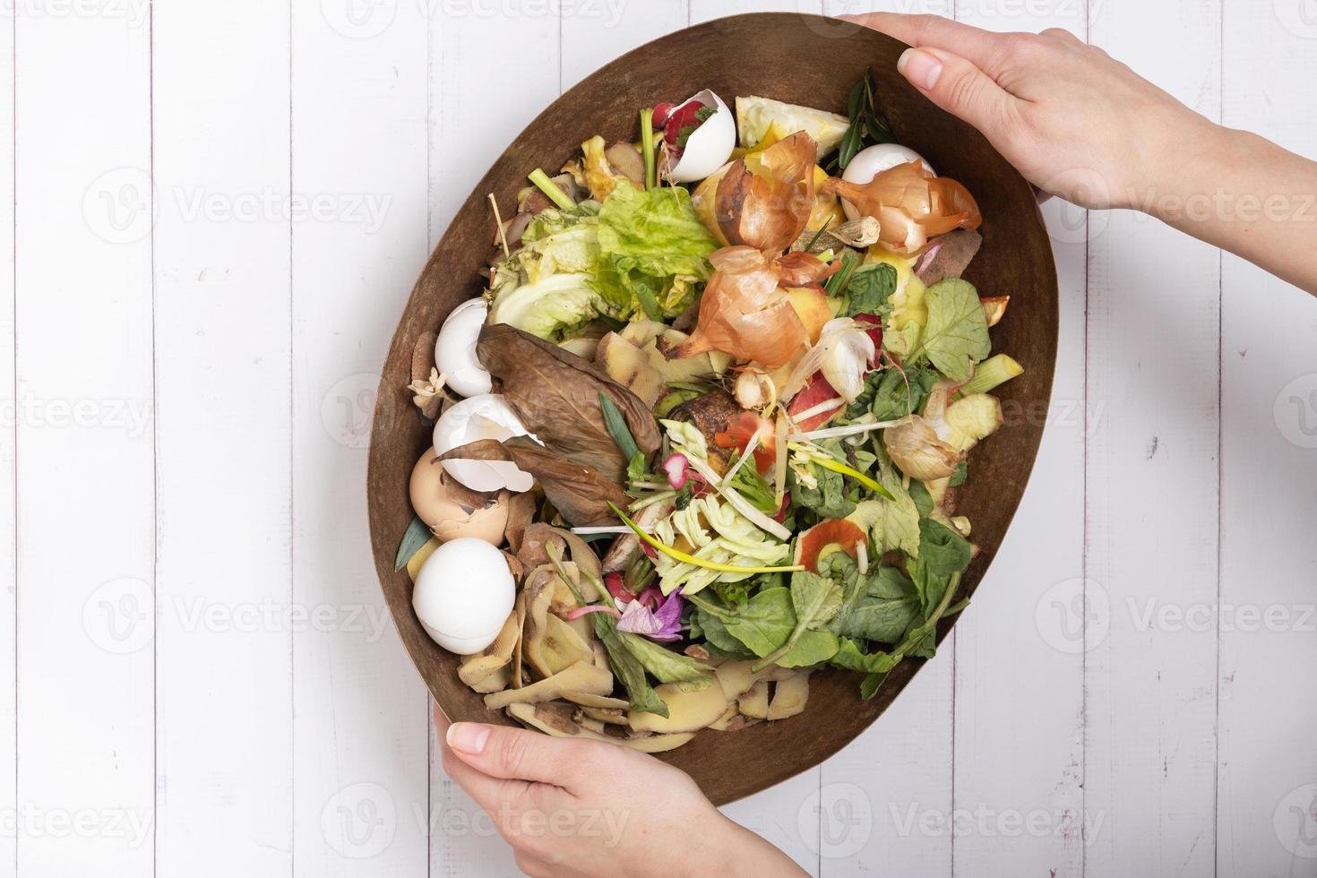 Organic garbage for compost on a wooden background. Composting concept flat lay, top view photo