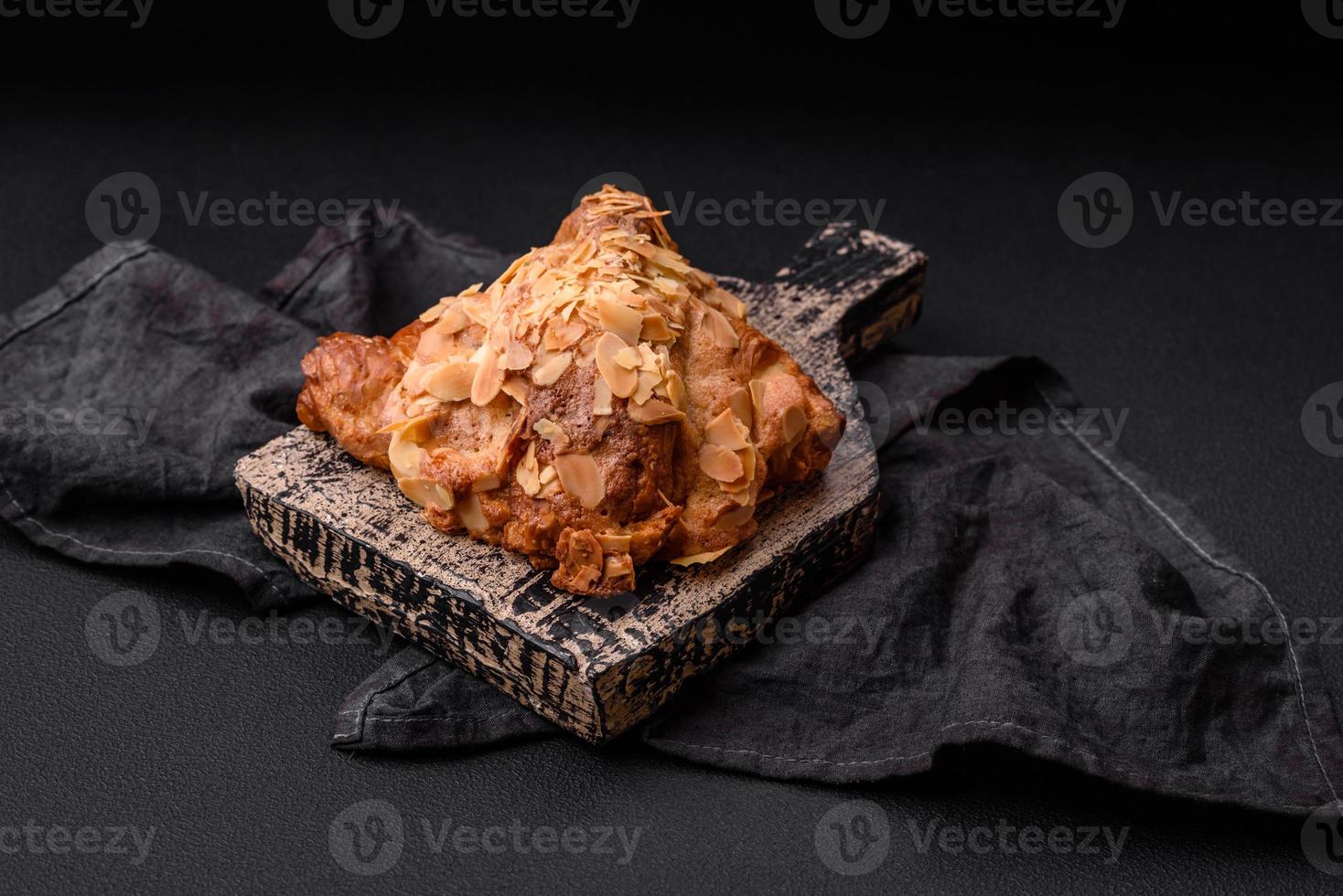 Fresh crispy croissant with almond chips and chocolate filling photo