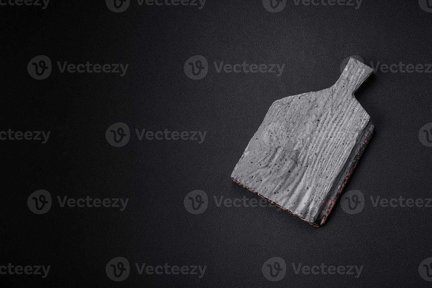 Empty wooden cutting board on dark concrete background photo