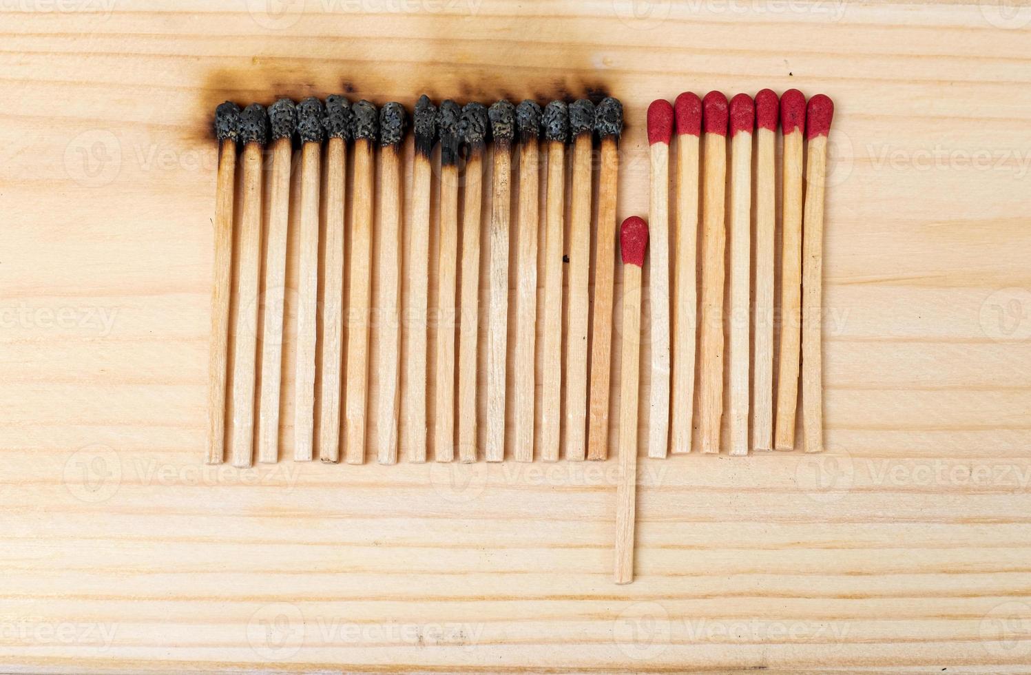 Row of burning matches and all matches on white background. spread of fire one match isolated to stop fire concept of the power of difference photo