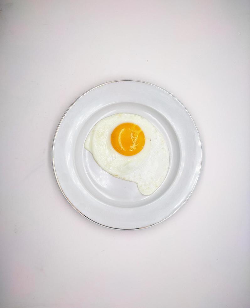 sunny side up egg served in white plate isolated in white background photo