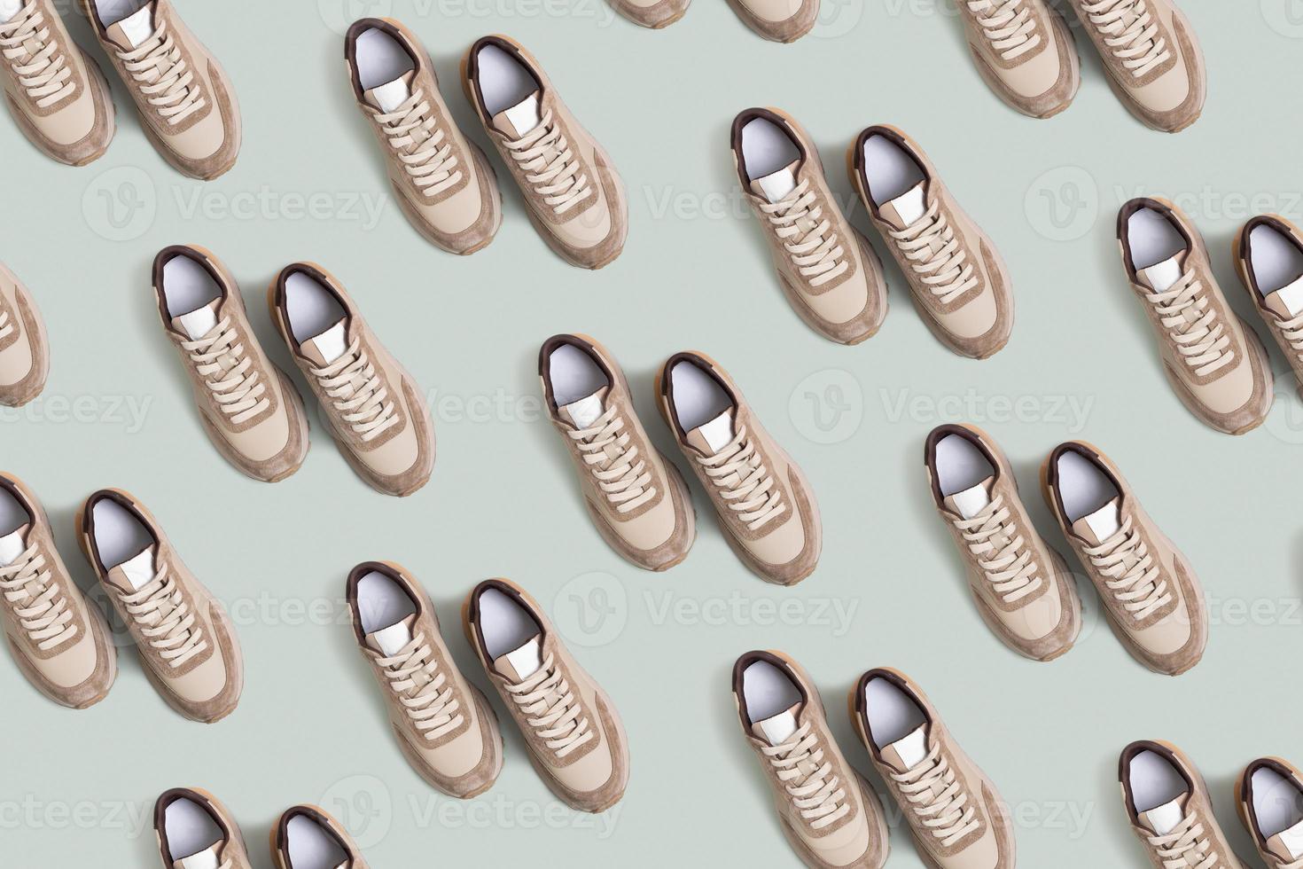 Beige women's leather sneakers pattern top view on a green-beige background. Spring or autumn casual shoes photo