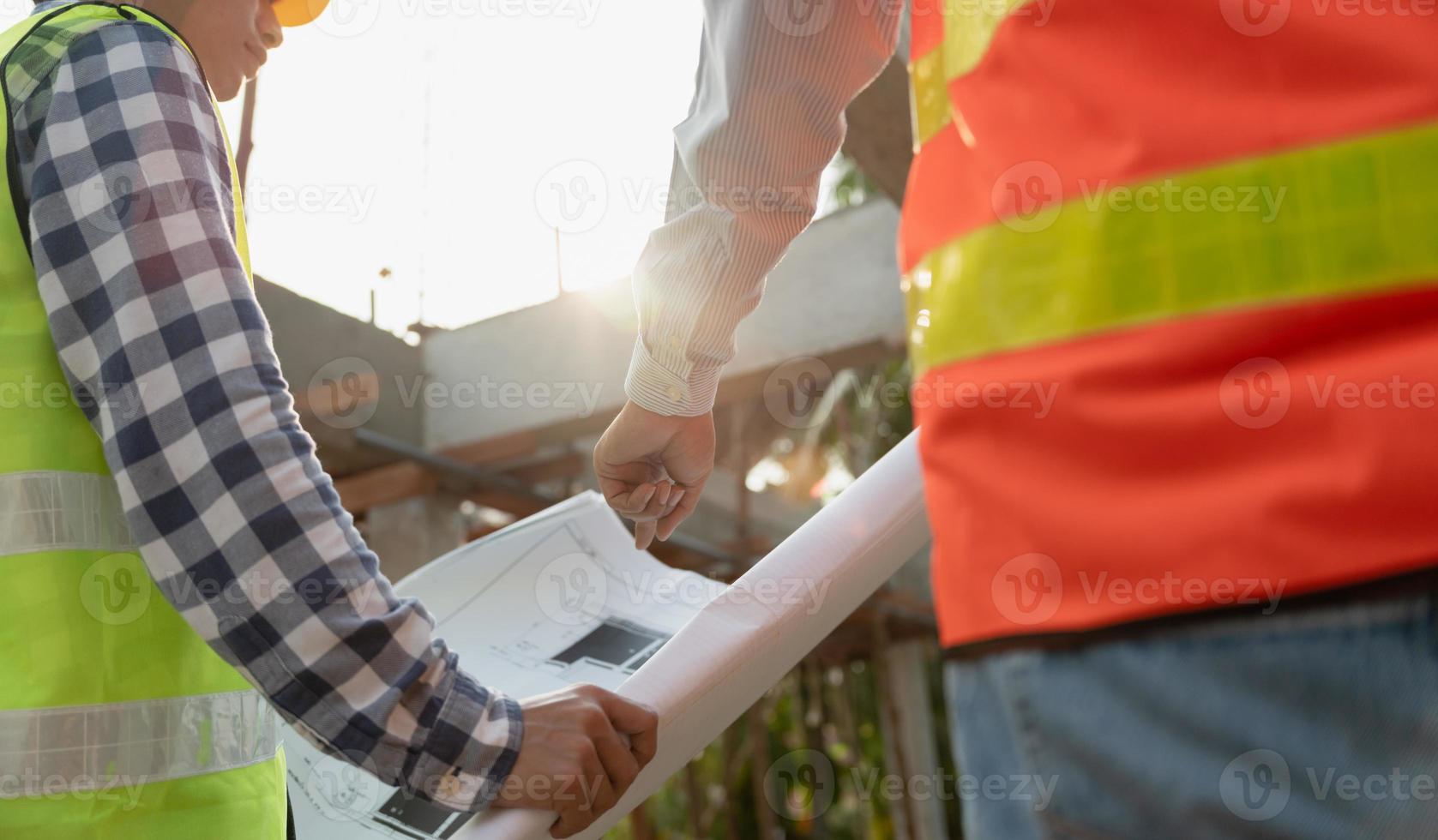 inspector or engineer is inspecting construction and quality assurance new house using a blue print. Engineer or architects or contactor work to build the house before handing it over to the homeowner photo