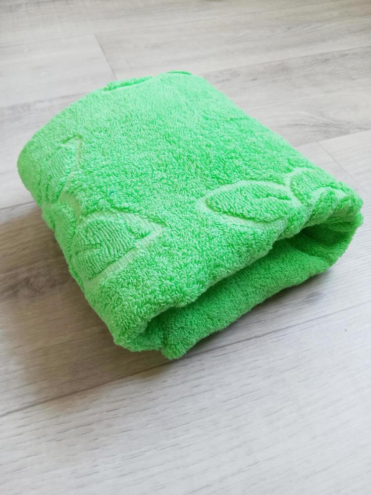 folded green towel on wooden background photo