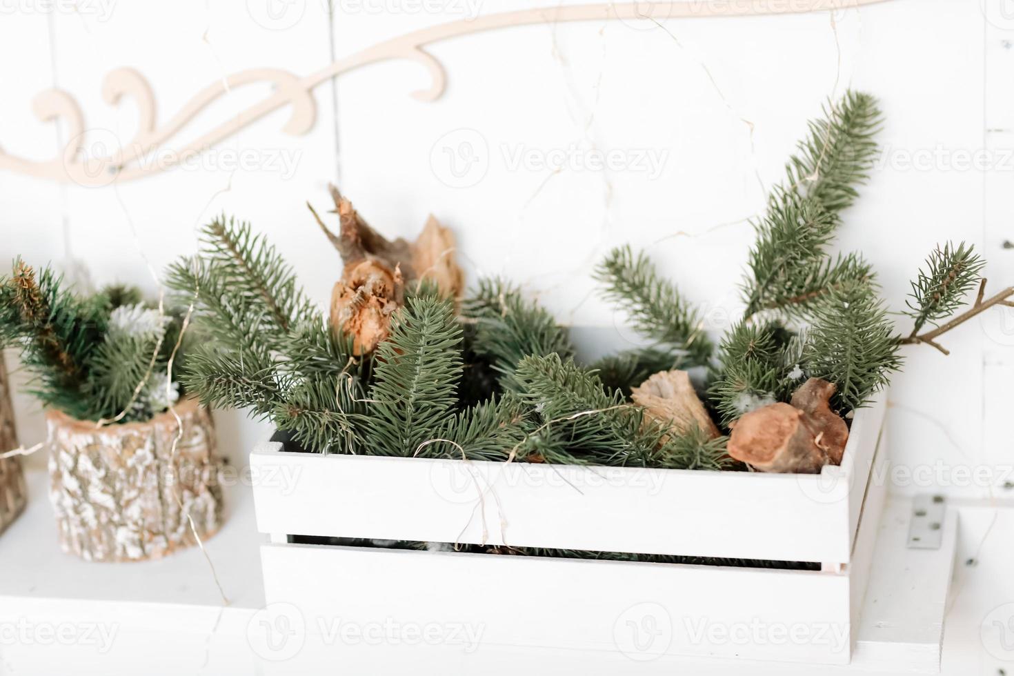 Christmas composition. Wooden box with Christmas fir branches and lighting garlands, on wooden white background. Merry Christmas, New Year, Happy Holidays, Template. Greeting card. 2023 photo