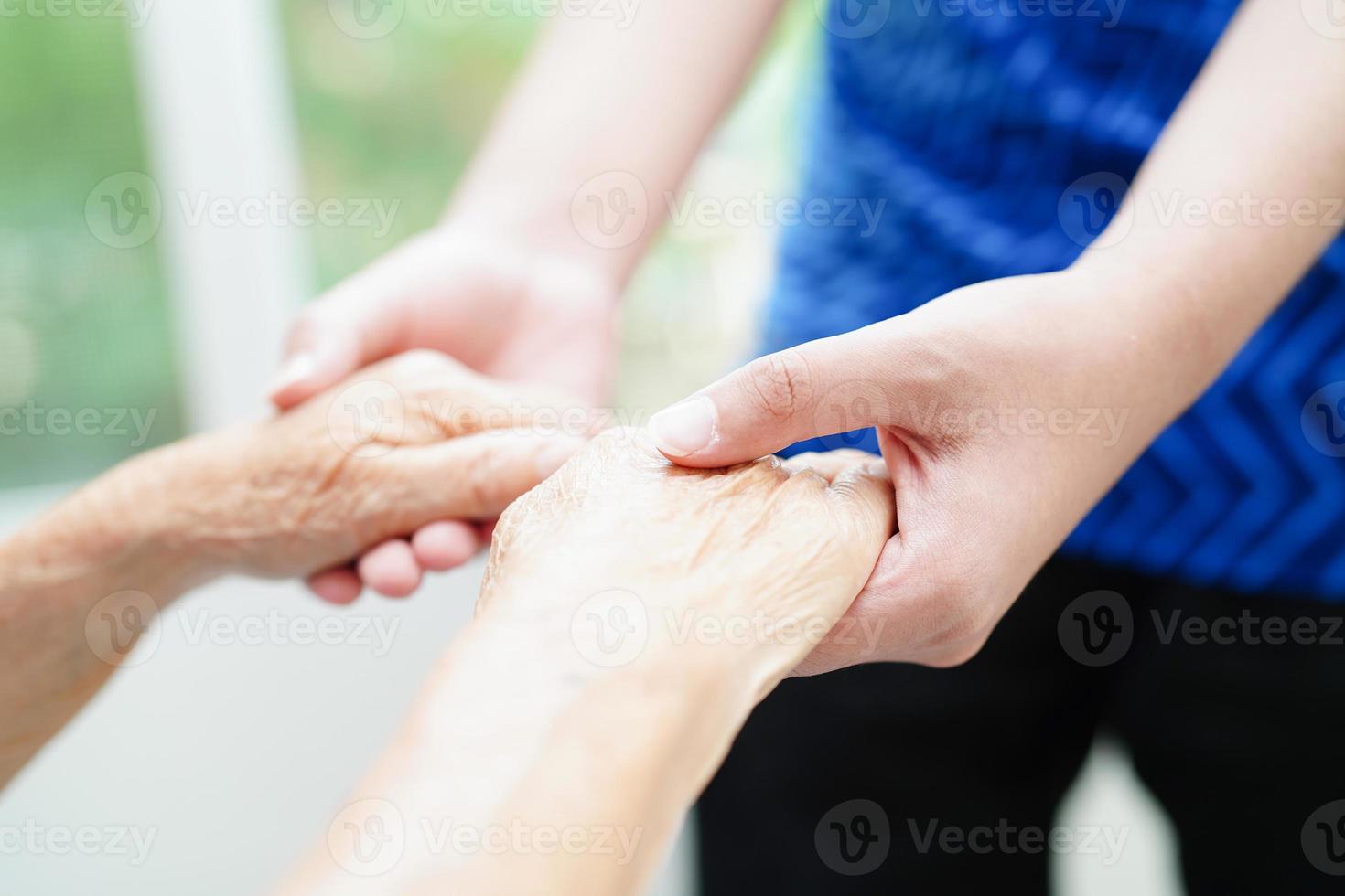 Asian young boy holding old grandmother woman hand together with love and care. photo