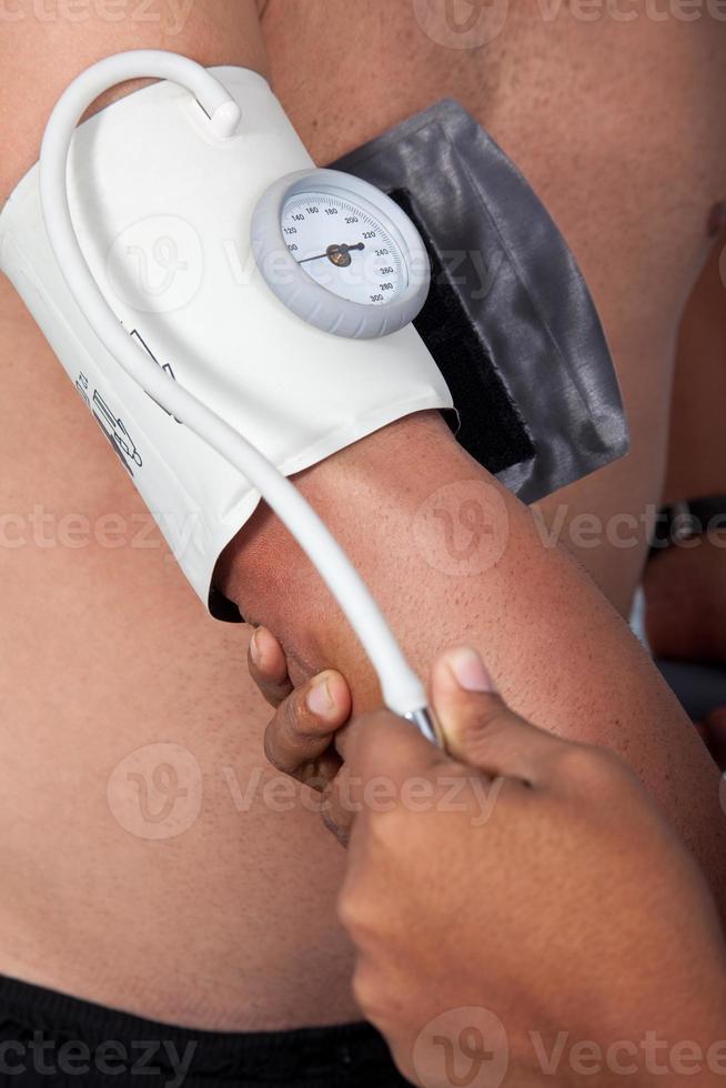 Doctor measuring blood pressure to a patient photo