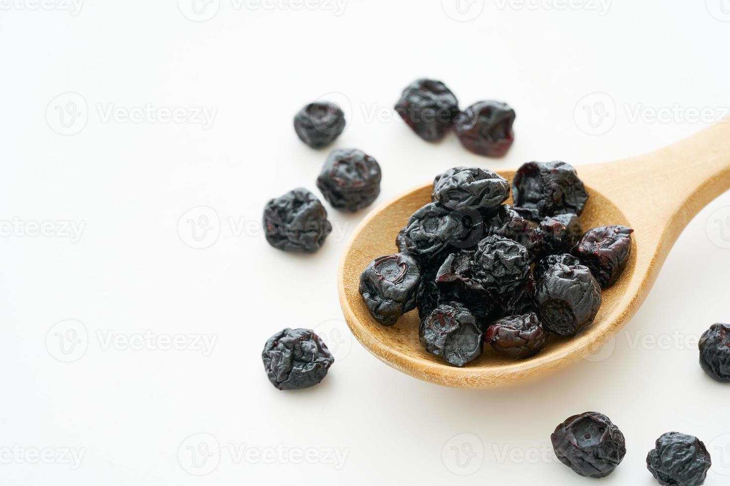 dry blueberry or blackberry in wood spoon isolated on white background. pile of dry blueberry or blackberry isolated. dry blueberry or blackberry isolated photo