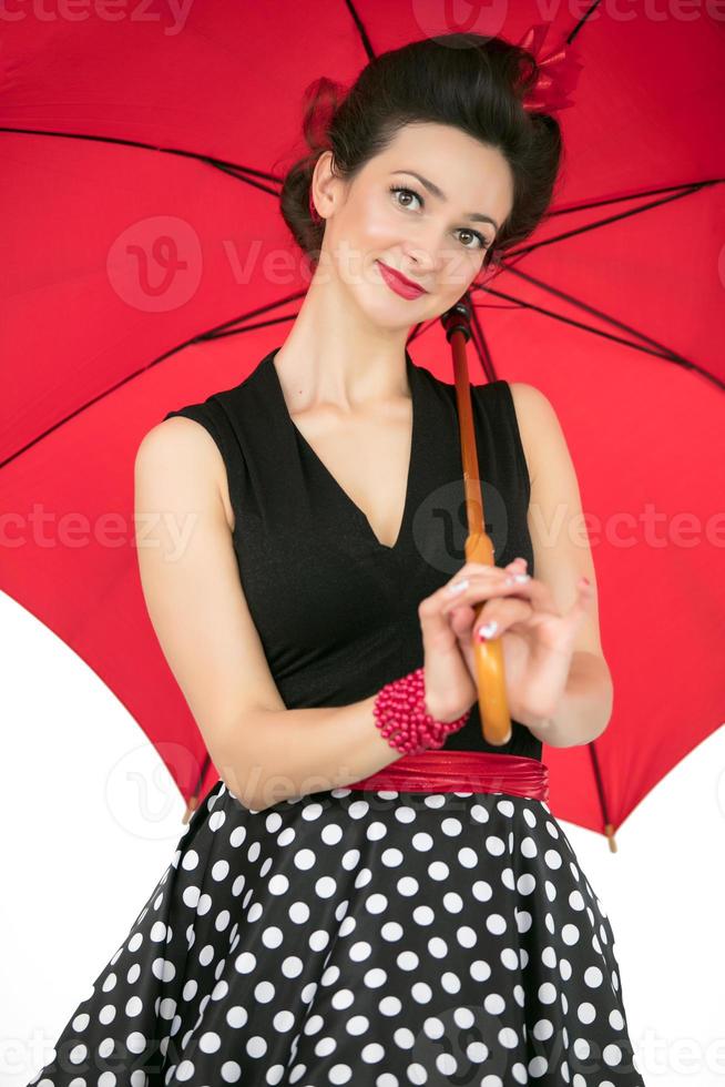 hermosa retro niña con un rojo paraguas en un blanco antecedentes. foto