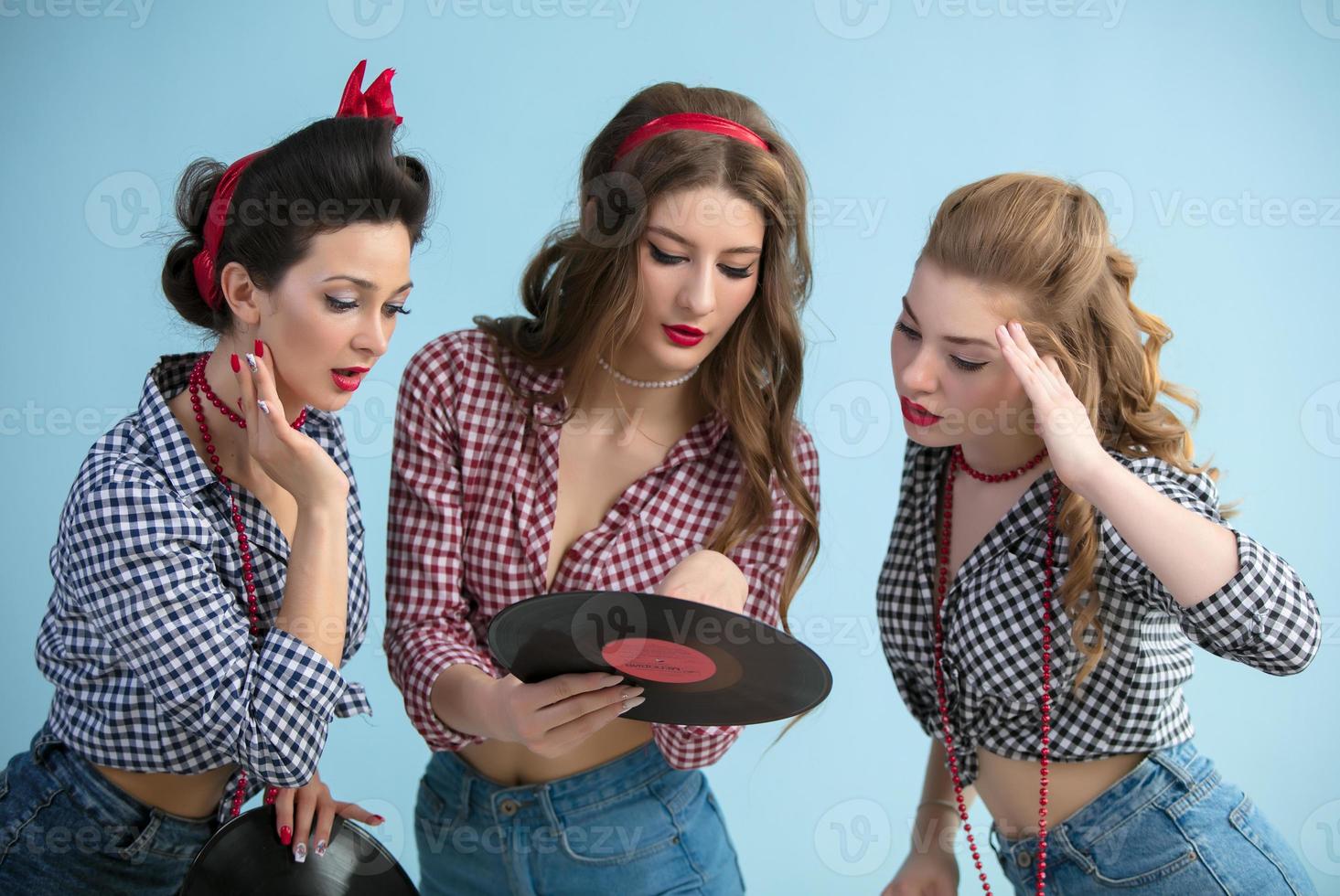 Three retro girls with vinyl records. photo