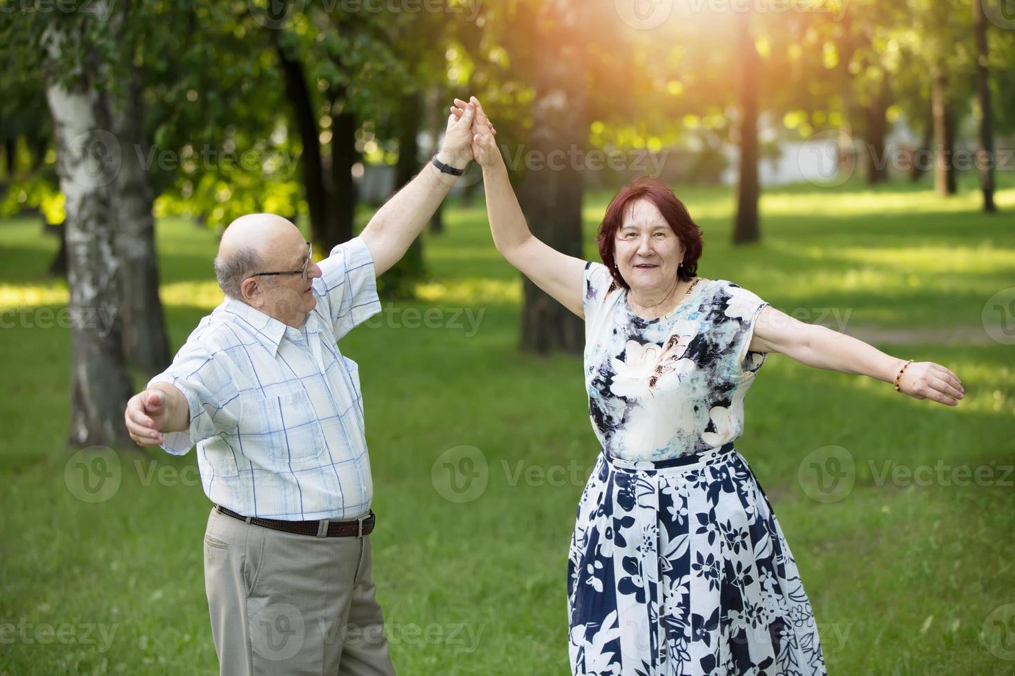 Happy elderly couple dancing. Handsome man and woman senior citizens. Husband and wife of old age for a walk. photo