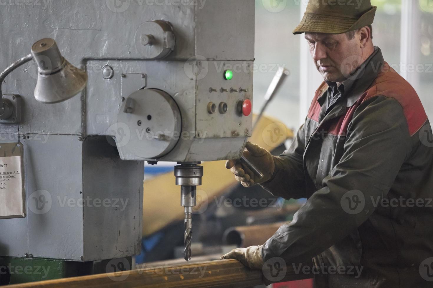 Worker at the current machine in the workshop. photo