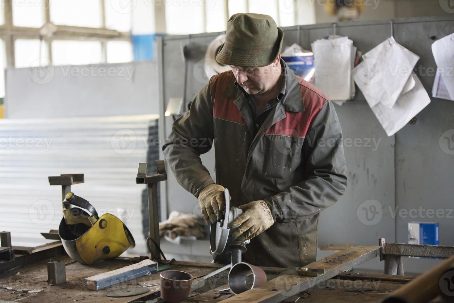 Worker in a workshop with a grinder. photo