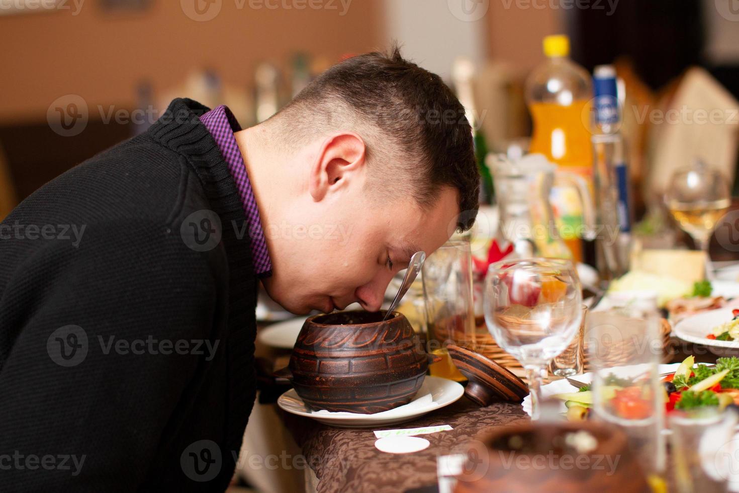 A man in a restaurant sniffing food. photo