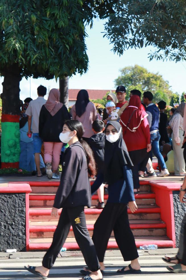 Kudus, January 2023. A snapshot of the crowds of car free day visitors crossing the zebra crossing to get to alun alun simpang 7 kudus. photo