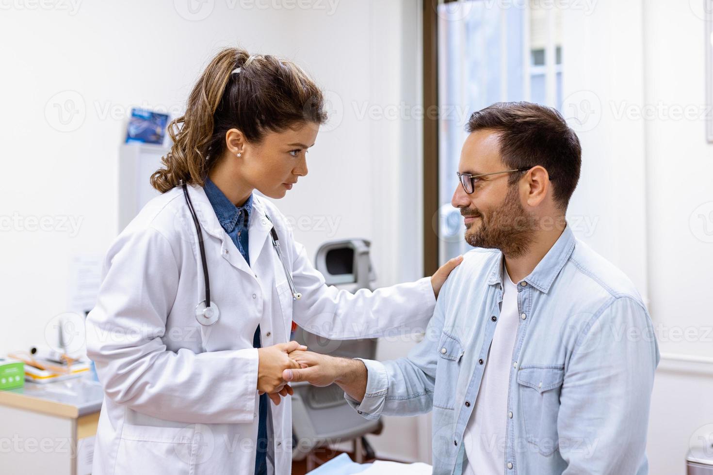 Young woman doctor or GP in white medical uniform consult male patient in private hospital. Female therapist speak talk with man client on consultation in clinic. photo