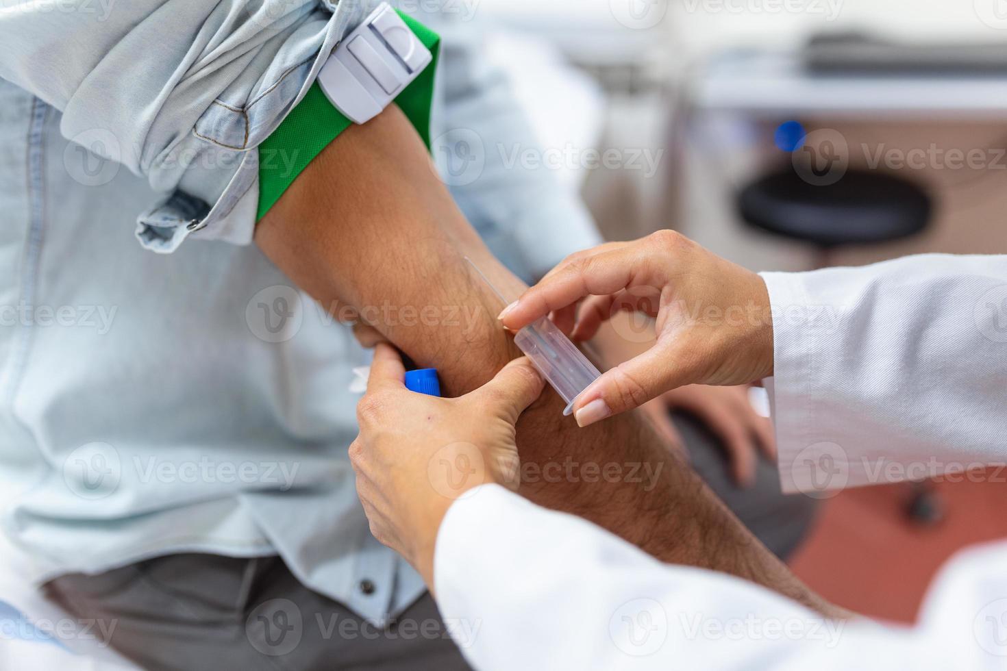 Preparation for blood test by female doctor medical uniform on the table in white bright room. Nurse pierces the patient's arm vein with needle blank tube. photo