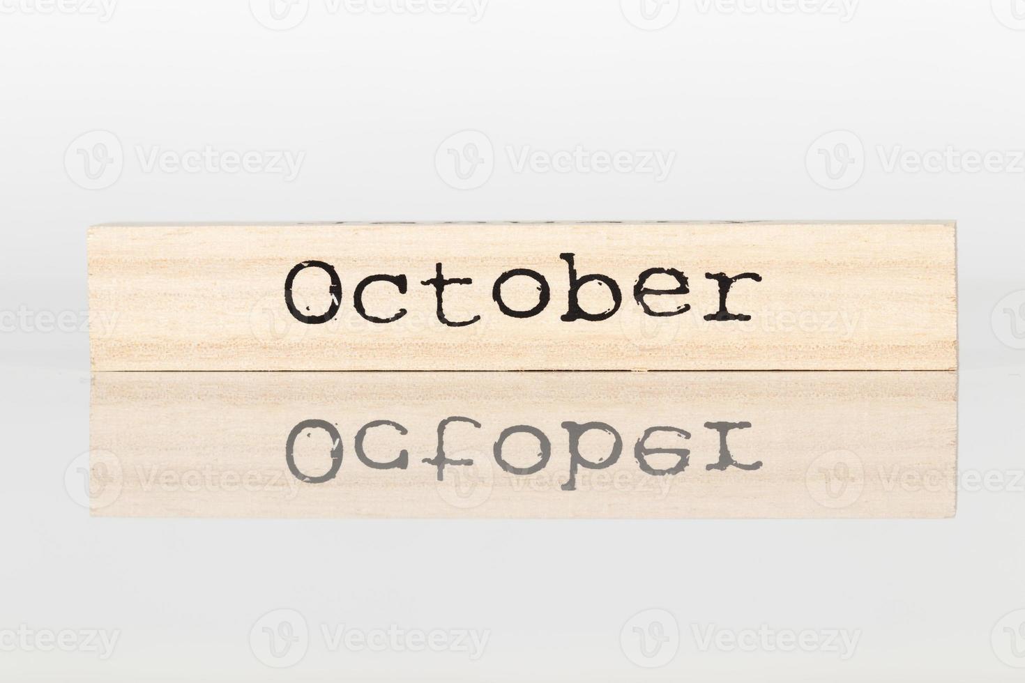 wooden cube with an inscription October on a white background photo