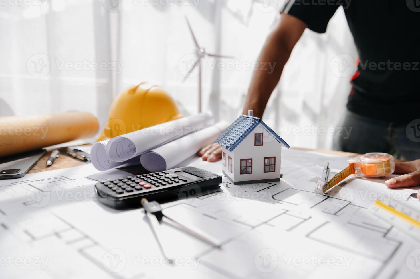 Close up of male architect hands making model house. Man architect working in the office. photo