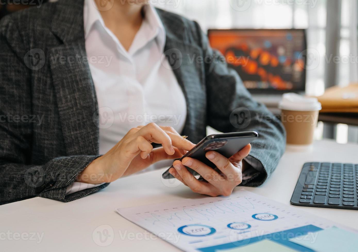 Businesswoman hand using smart phone tablet and laptop with social network diagram on desk as concept in morning light. photo