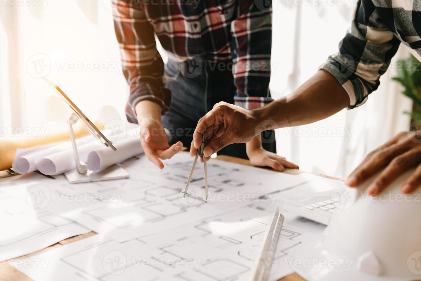 Arquitecto creativo proyectando sobre los grandes dibujos en la oscura oficina loft o cafetería a la luz de la mañana foto