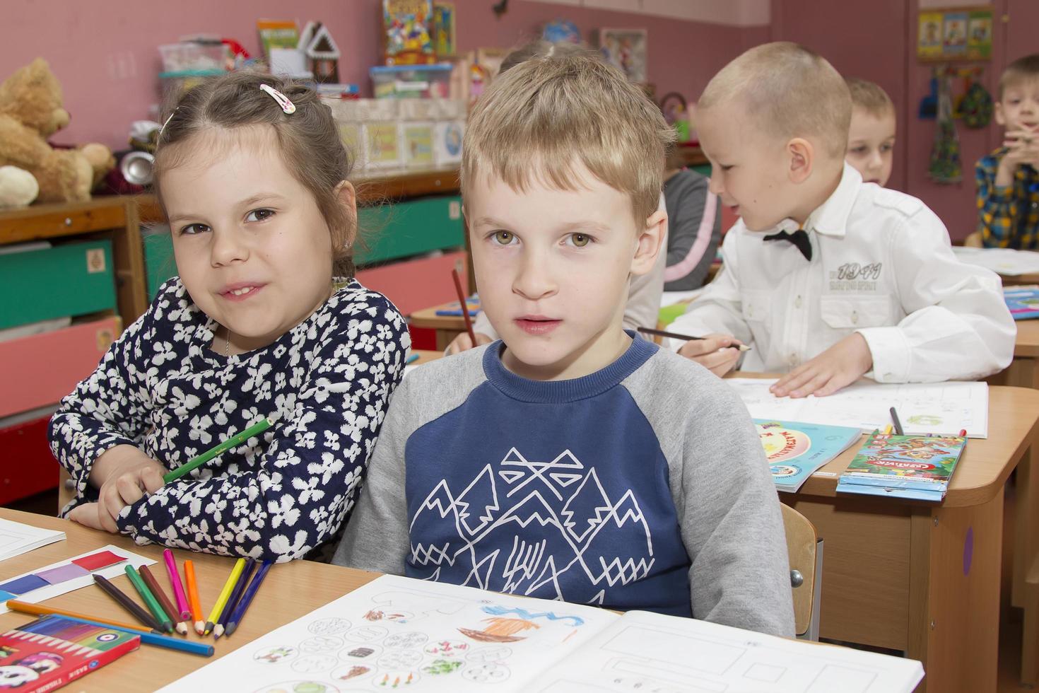 Children sit at desks in the classroom. photo