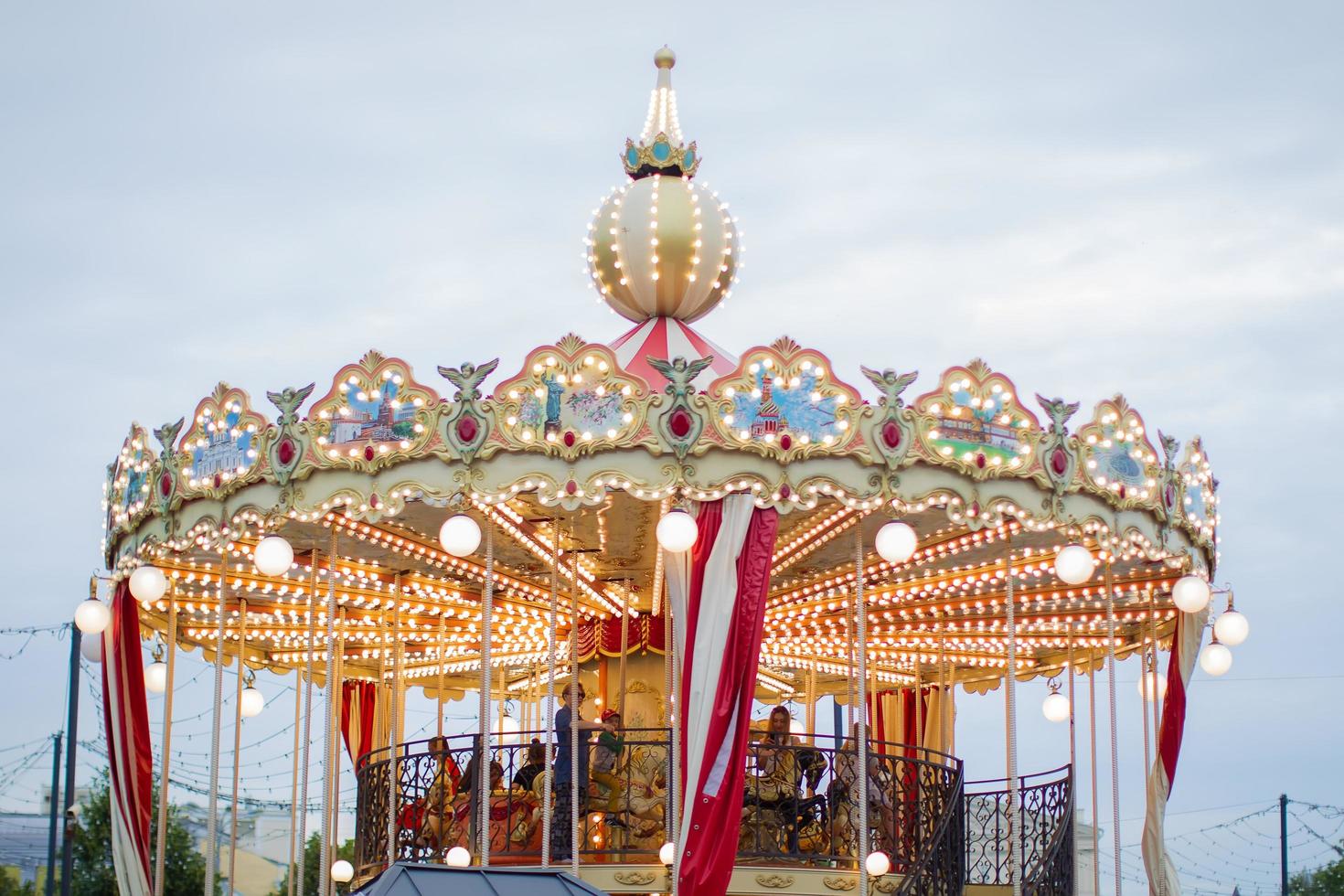 Fragment of a carousel with people against the sky. photo