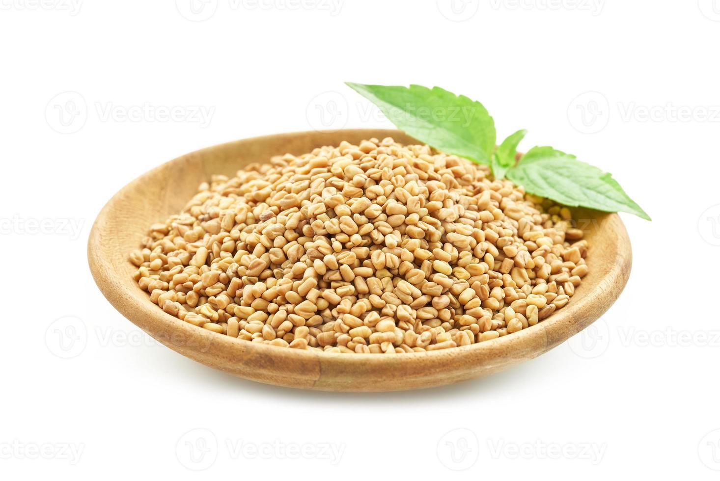 fenugreek seed in wood plate and green leaves isolated on white background. fenugreek isolated photo