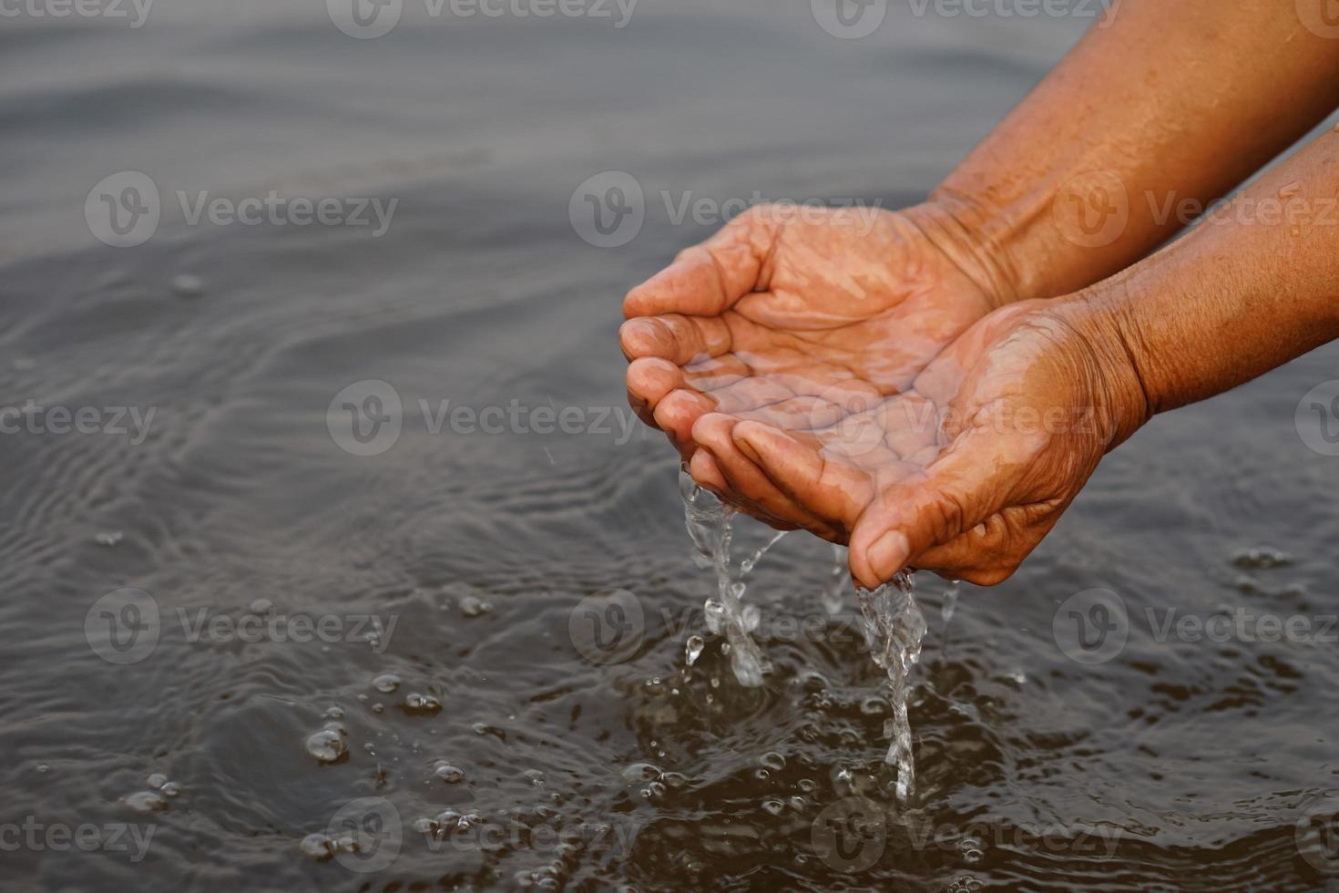 Closeup hands hold some water in river. Concept, explore, inspect clarify and quality of water from natural source. Ecology survey. Environment conservation. photo