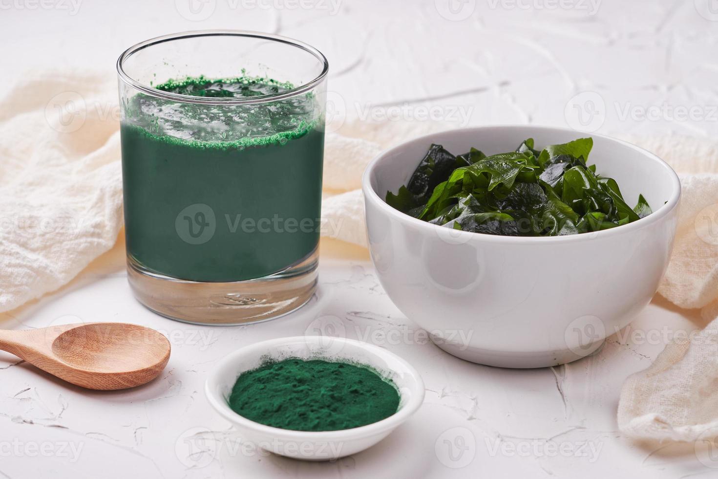 Top view laminaria Kelp seaweed and spirulina powder in white bowl