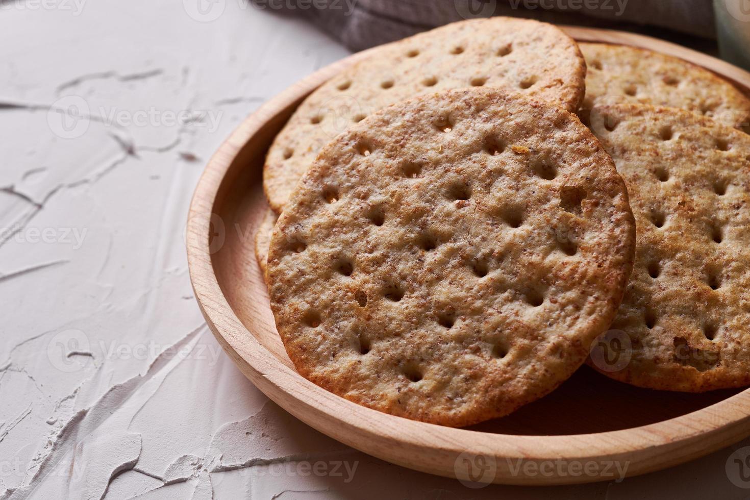 whole grain wheat round crackers on white table background photo