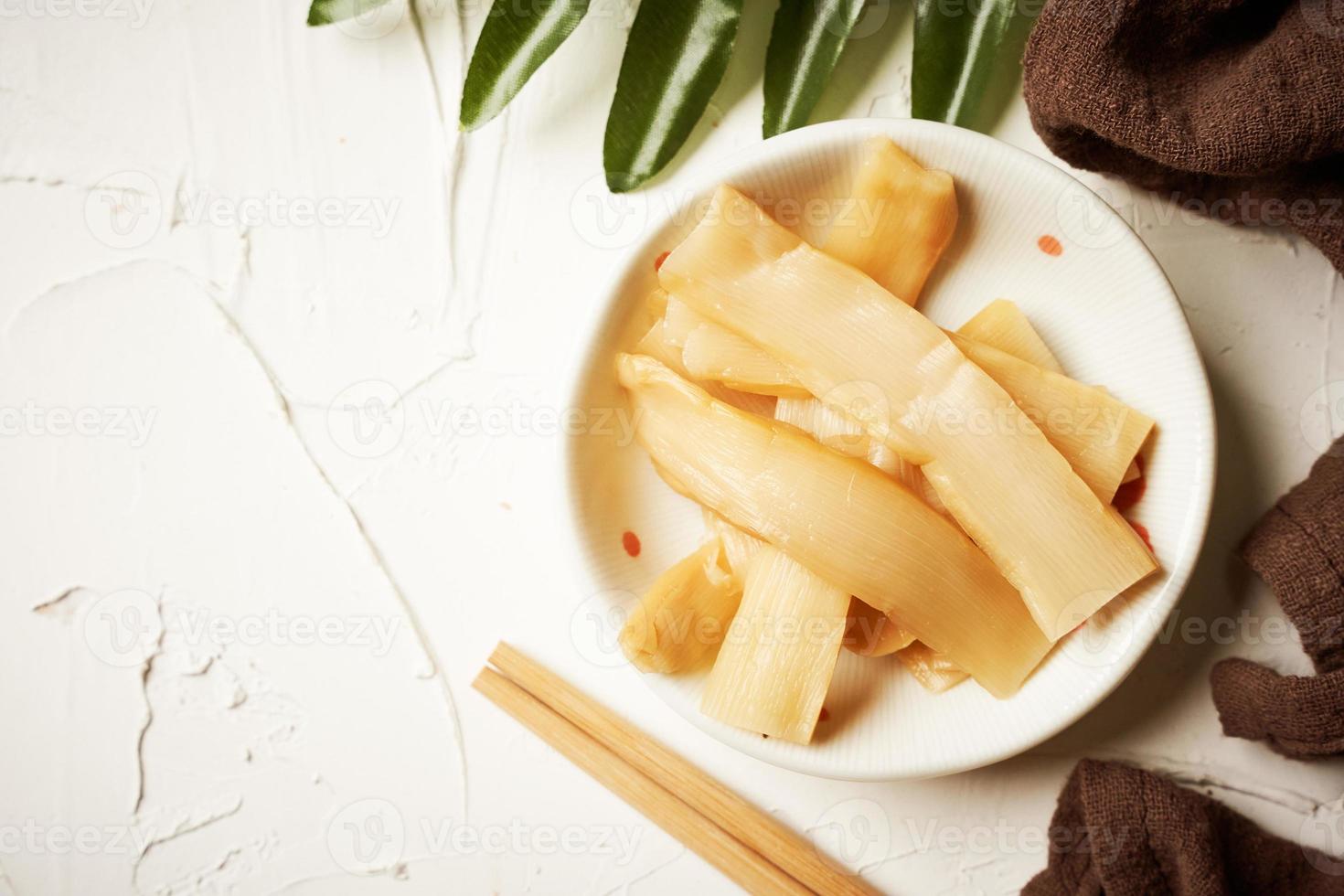 top view Ajitsuke Menma Pickled Bamboo Shoot in a white dish on white table background with copy space photo