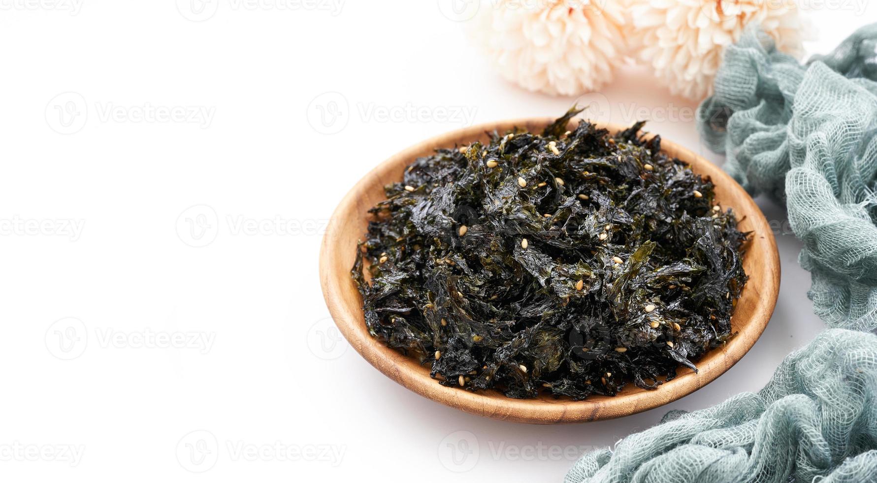 roasted nori seaweed and sesame topping in wood plate on white background. Gim, laver, nori photo