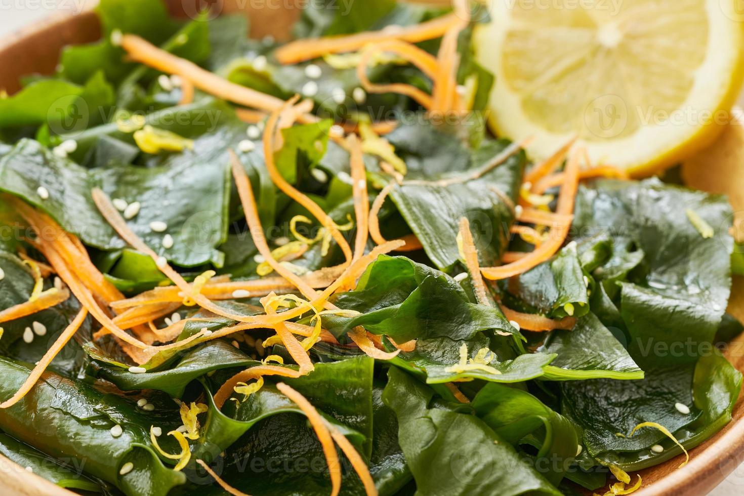 close up salad laminaria Kelp or wakame seaweed salad in wood bowl on white table background with copy space. salad laminaria Kelp or wakame seaweed salad food photo