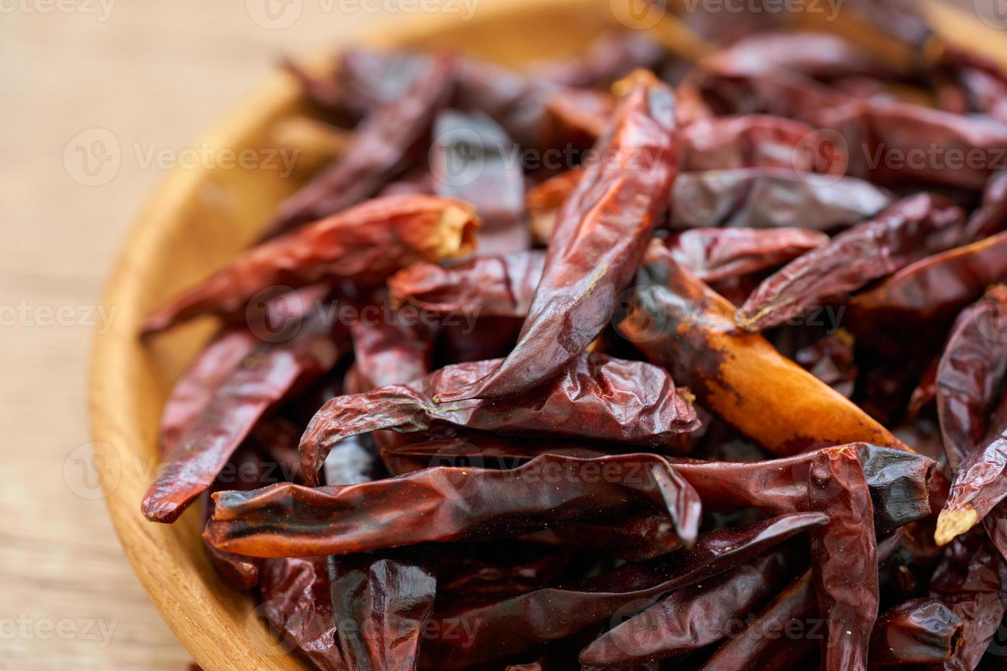 cerca arriba pila de seco rojo chile chile pimienta en madera plato en de madera mesa comida especias antecedentes. chile, chile, pimienta foto