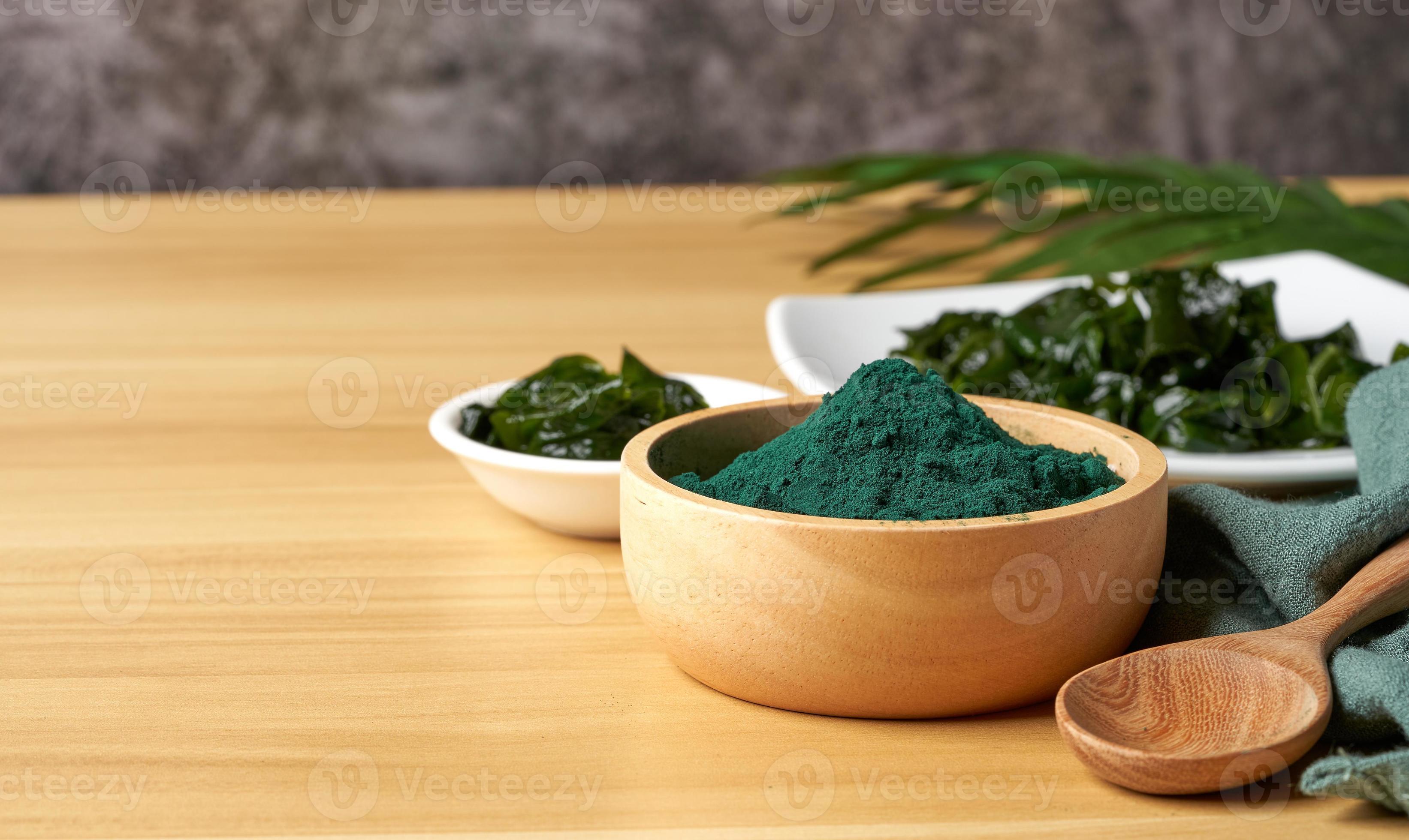 laminaria or kelp seaweed and spirulina powder in wood bowl and spoon