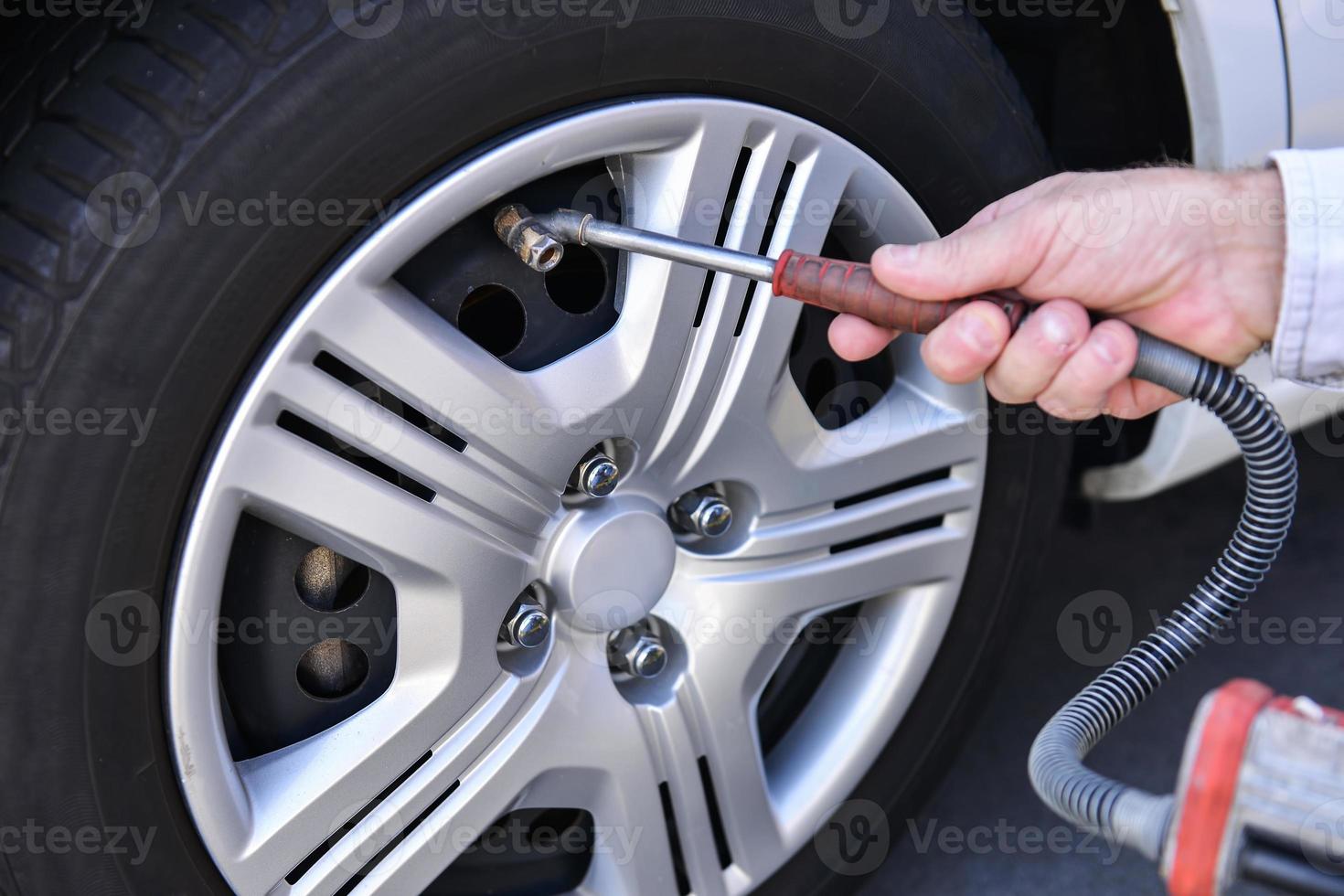 hand and vehicle wheel add air pressure photo