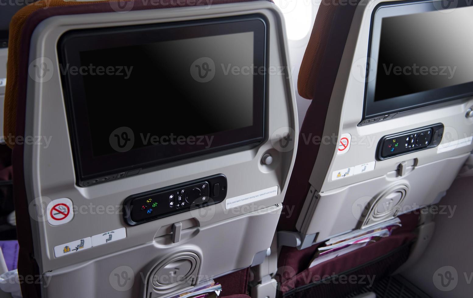 the Monitor and rremote on back seats in the cabin of the plane photo