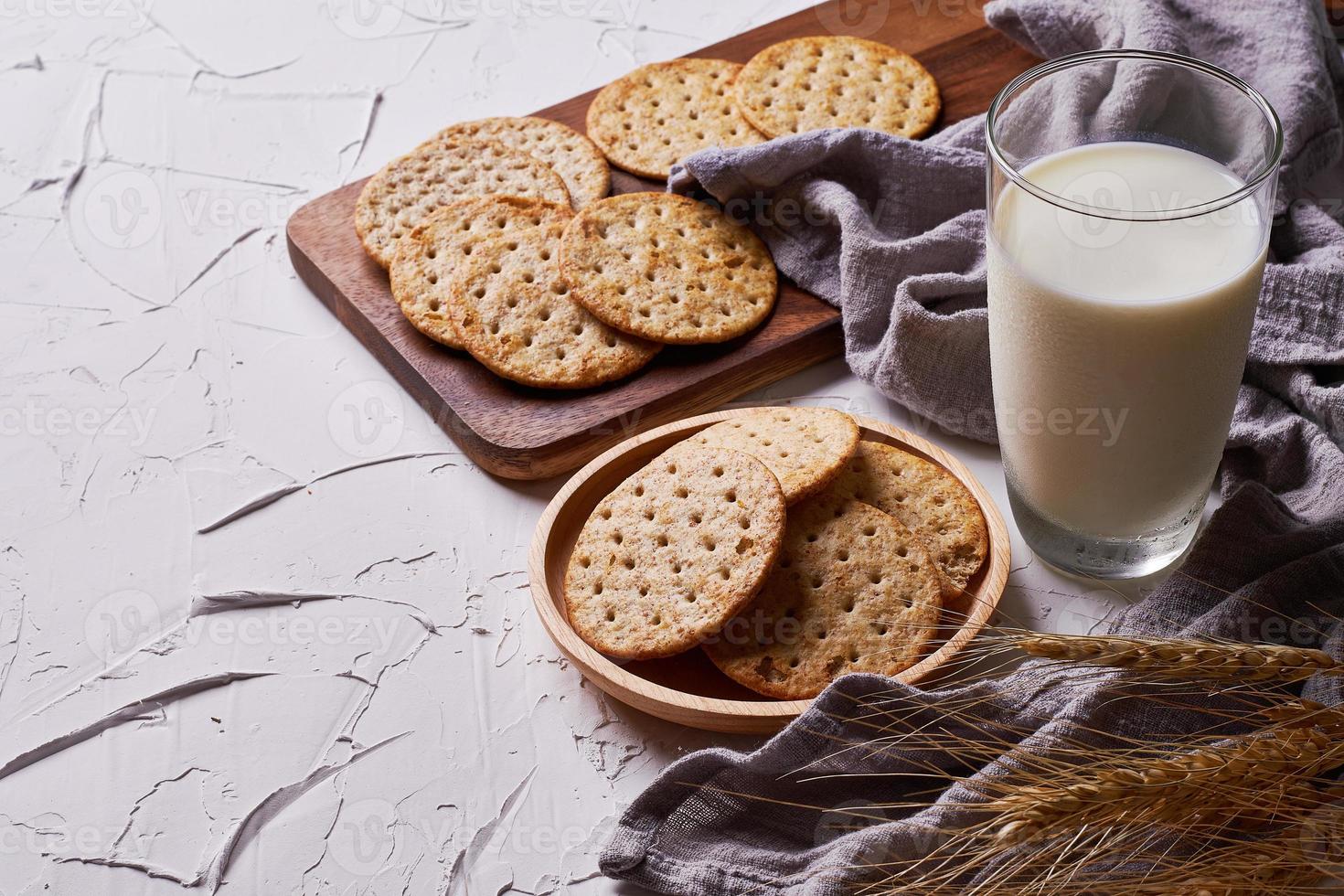 whole grain wheat round crackers and milk on white table background photo