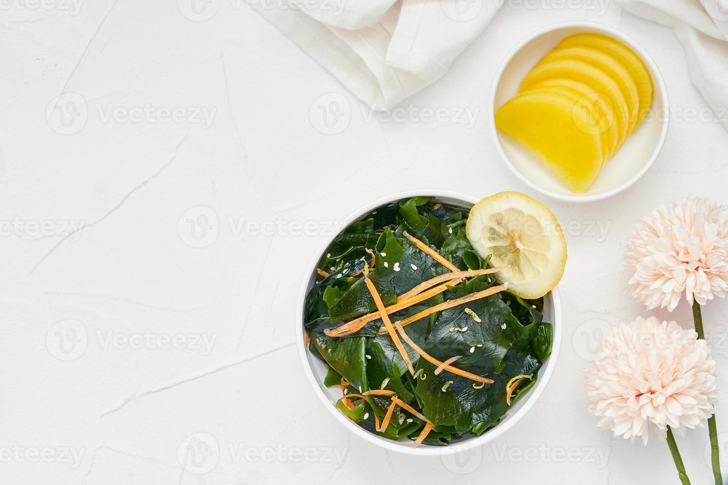 top view flat lay. overhead salad laminaria Kelp or wakame seaweed salad in bowl on white table background with copy space. salad laminaria Kelp or wakame seaweed salad food photo