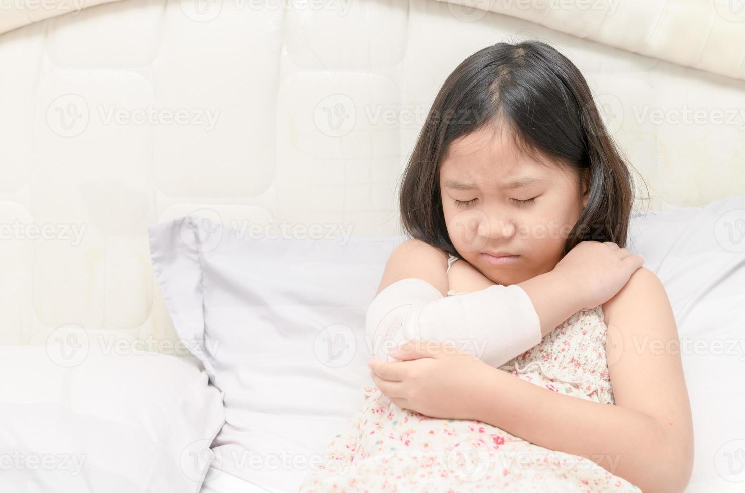 pequeño niña con su dañado Derecha brazo foto