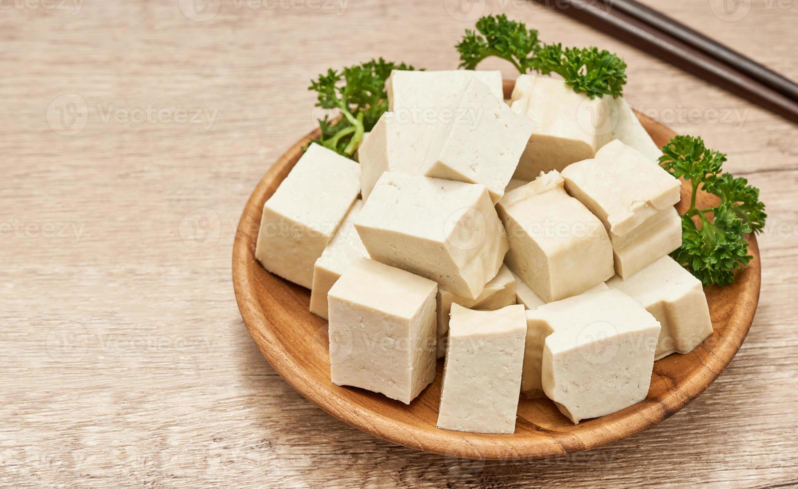 pila de blanco cubo tofu en madera plato en mesa cocina antecedentes. Fresco blanco cubo tofu sano comida en cocina antecedentes. montón de blanco cubo tofu antecedentes foto