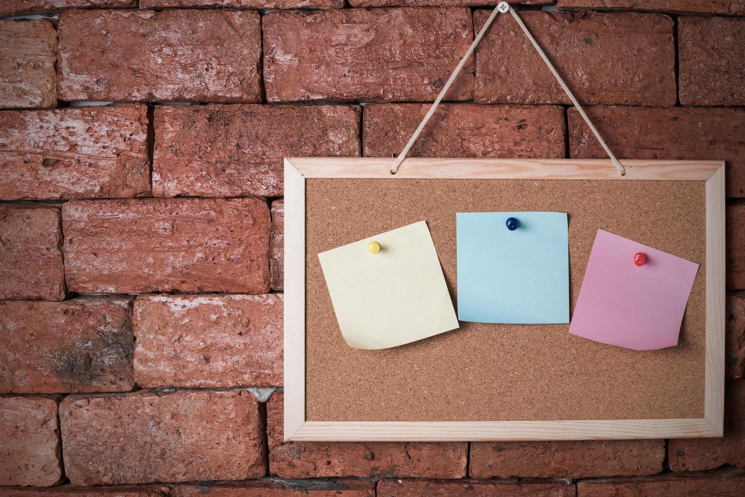 paper note on wood board and old brick background photo