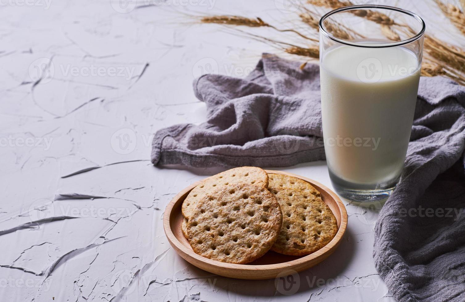 whole grain wheat round crackers and milk on white table background photo