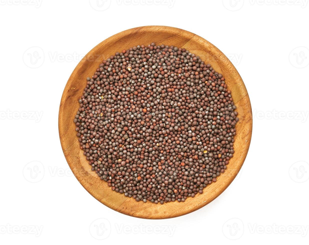 top view black mustard seed in wood plate isolated on background. a pile of black mustard seed in wood plate isolated on background. heap of black mustard seed in wood plate isolated on background photo